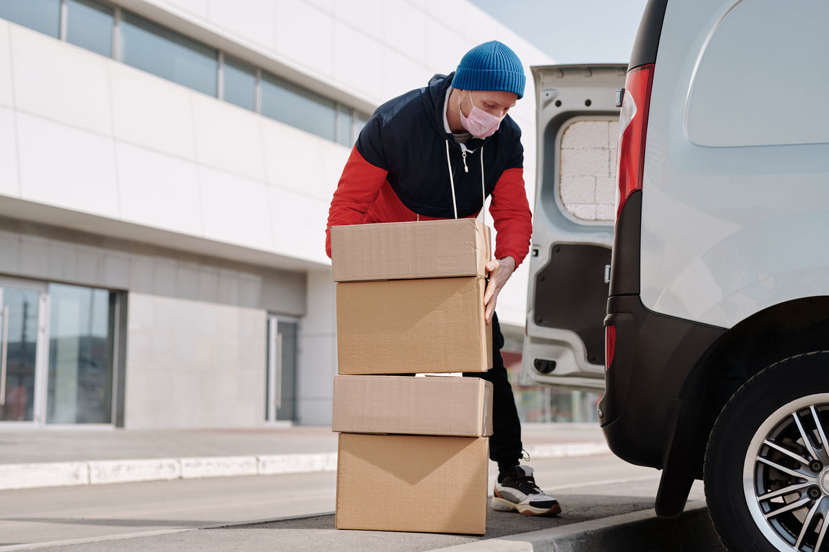 Courier delivering boxes from a van