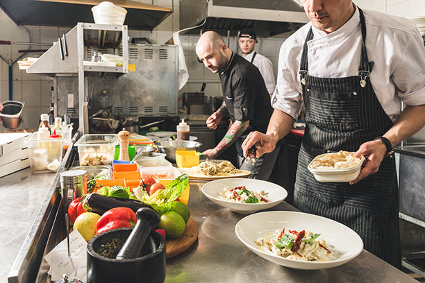 Chefs cooking in a busy restaurant kitchen
